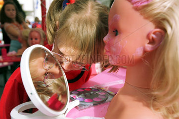Berlin  Maedchen sucht im Spiegel die Puppe