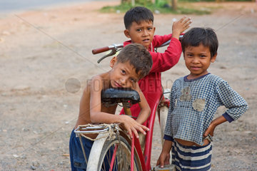 Kampot  Kambodscha  drei Jungen mit einem Fahrrad am Strassenrand