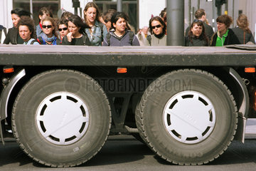 Fussgaenger hinter Reifen eines wartenden LKWs