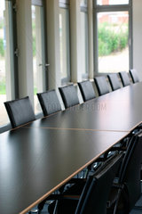 Konferenzsaal mit schwarzen Stuehlen und Tischen