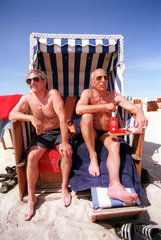 Sich sonnende Herren im Strandkorb an der Ostsee