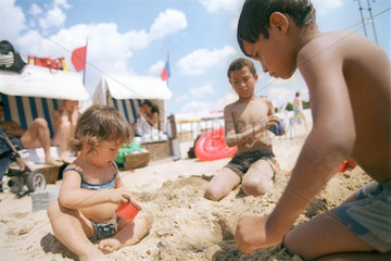 Kinder buddeln im Sand in einem Strandbad Berlins
