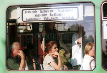 Menschen sitzen in einer Strassenbahn in Basel