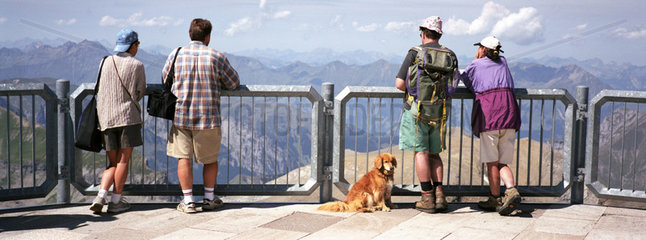 Touristen u. Hund bestaunen Berge in der Schweiz