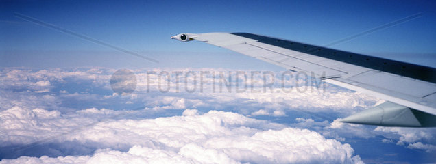 Wolkendecke und Tragflaeche eines Flugzeuges