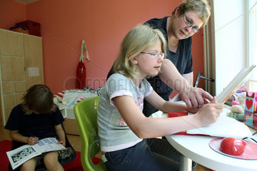 Berlin  Deutschland  Kinderdorf-Mutter hilft bei den Schularbeiten