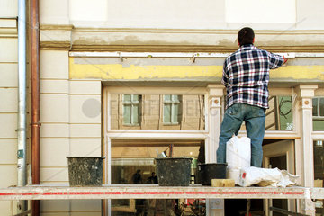 Handwerker arbeitet an einer Hausfassade