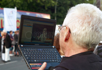 Berlin  Deutschland  ein Mann chattet drahtlos ueber sein Laptop auf der Strasse
