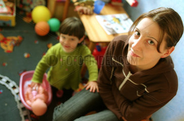 Junge Frau mit kleiner Tochter im Kinderzimmer