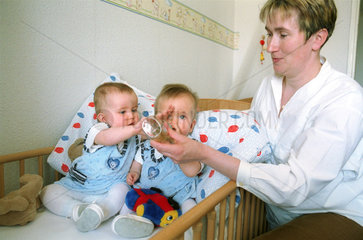 Mutter fuettert weibliche Zwillings-Babys  Berlin