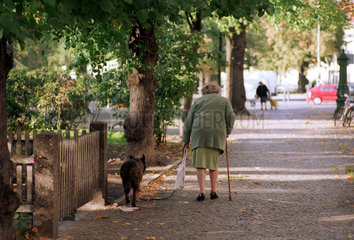 Berlin  Alte Frau mit Krueckstock und Hund
