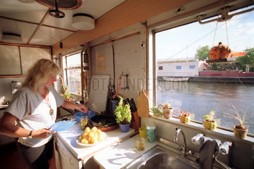 Berlin  Frau in der Kueche ihres Hausbootes