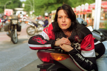 Berlin  Junge Frau mit Motorrad