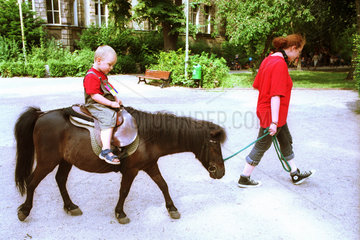 Kleiner Junge reitet auf Pony  Berlin
