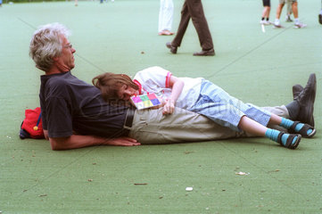 Kleines Maedchen liegt auf ihrem Vater