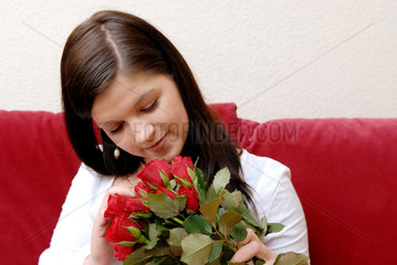 Berlin  eine junge Frau mit einem Strauss roter Rosen
