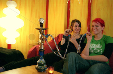 Berlin  zwei junge Frauen rauchen Wasserpfeife