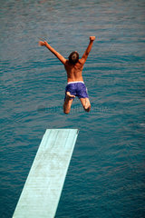 Berlin  Junge springt vom Sprungbrett ins Wasser
