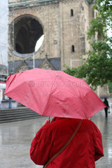 Berlin  Touristin mit Regenschirm vor der Gedaechtniskirche