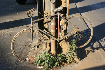 Berlin  kaputtes und verrottetes Fahrrad angekettet