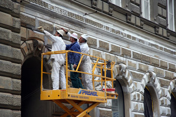 Wien  drei Handwerker renovieren Fassade