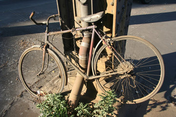 Berlin  kaputtes und verrottetes Fahrrad angekettet