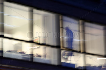 Berlin  Mann steht auf einer Leiter am Fenster  verwackelt
