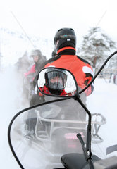 Saelen  Schweden  Fahrer eines Schneemobils schaut in seinen Rueckspiegel