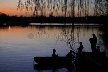 Potsdam  Silhouette einer Familie an einem See in der Abendsonne