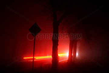 Grossziethen  Deutschland  Autoverkehr auf einer Landstrasse bei Nacht und Nebel
