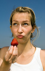 Junge Frau isst eine Erdbeere  Berlin