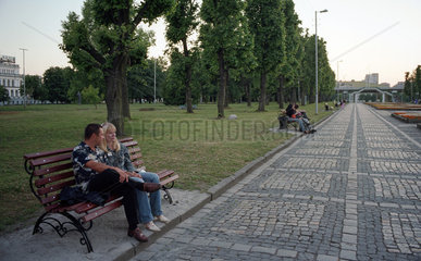 Menschen auf Parkbaenken in einer Parkanlage  Kaliningrad  Russland