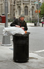 New York City  USA  Obdachloser wuehlt in einem oeffentlichen Muelleimer