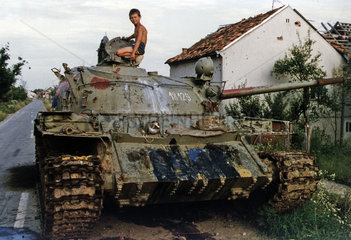 Kalesija  Bosnien und Herzegowina  Junge auf einem Panzer