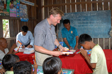 Phum Chikha  Kambodscha  kambodschanisch  Christian Kruppa beim Verteilen von Schulmaterial