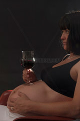 Freiburg  Deutschland  eine schwangere Frau mit einem Glas Rotwein