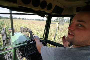 Landwirt beim unterpfluegen mit dem Traktor