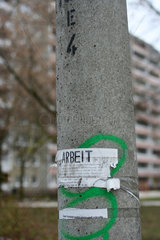 Berlin  Zettel mit der Ueberschirft ARBEIT an einer Laterne
