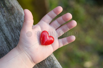 Carabietta  Schweiz  glaesernes  rotes Herz in einer Kinderhand