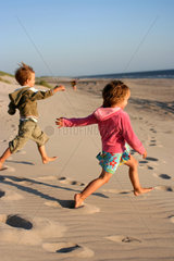 Daenemark  Junge und Maedchen laufen zum Strand