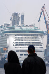 Hamburg  zwei Besucher schauen auf ein Schiff im Hafen
