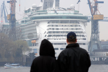 Hamburg  zwei Besucher schauen auf ein Schiff im Hafen