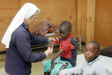 Kenia  ein behinderter Junge wird von einer katholischen Schwester behandelt