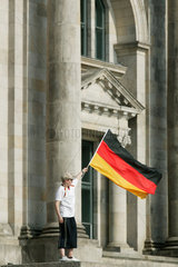 Berlin  Junge schwenkt Deutschland-Fahne vor dem Reichstag
