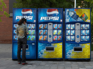 Toronto - Eine junge Frau an einem Getraenkeautomaten von Pepsi