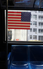 New York City  USA  US-Nationalflagge auf der Scheibe eines Busses