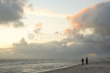 Daenemark  Urlauber am Strand bei Sonnenuntergang