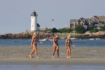 Gloucester  USA  Hafeneinfahrt mit Leuchtturm  drei junge Frauen laufen im Watt