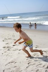 Daenemark  Junge tobt am Strand