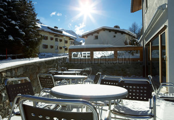Surlej - Die verschneite Terrasse eines Cafes mit Mobiliar